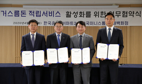 From left to right are Emart24 CEO Kim Song-yong, Bank of Korea Deputy Governor Yoon Myun-shik, Ministop Korea President Shim Kwan-sub and Hyundai Department Store Executive Vice President Jung Jee-young at the central bank’s headquarters in central Seoul on Tuesday. [EMART24]