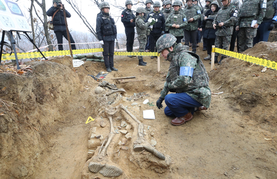 Former Prime Minister Lee Nak-yon kneels in front of the remains of a fallen soldier that were excavated at Arrowhead Ridge in the demilitarized zone (DMZ) last November. [YONHAP]