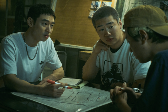 In a scene from ’Time to Hunt.“ Jun-seok (played by Lee Je-hoon), far left, and his friends discuss how to rob a gambling place. [NETFLIX] 