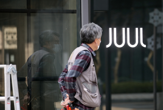 A man helps shut down a Juul Labs store in Gwangwhamun in central Seoul in March. The U.S.-based e-cigarette maker on Wednesday said it is halting operations in Korea. [YONHAP]
