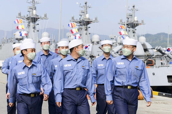 Sailors, wearing face masks, disembark from their battle ship on Wednesday after the central government officially ended social distancing campaign. [YONHAP]