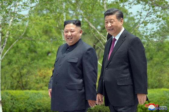 Chinese President Xi Jinping, right, and North Korean leader Kim Jong-un take a walk at the Kumsusan State Guesthouse in Pyongyang on June 21, 2019, in this photo released by the North's state-run Korean Central News Agency. [YONHAP] 