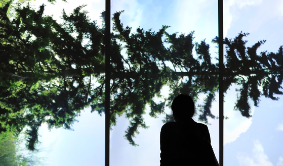 A guest at the MMCA Seoul’s new exhibition ’Axis of Horizon“ looks at Eija-Liisa Ahtila’s ’Horizontal-Vaakasuora“ (2011), which depicts the difficulty in capturing nature -- and any other subject -- in its truest form, and rethinking the relationship between people and nature. [YONHAP]