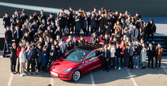 Tesla Model 3 owners pose at an event at Seoul Grand Park in Gwacheon, Gyeonggi, last year, celebrating the arrival of the electric vehicles. [YONHAP]