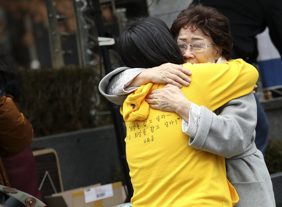 Lee Yong-soo, a former "comfort woman," right, hugged Yoon Mee-hyung, former head of the Korean Council, during the Wednesday demonstration in front of the Japanese Embassy on Jan. 8, 2020. Their relationship of 30 years recently fell apart after Lee's press conference criticizing Yoon's integrity. [YONHAP] 