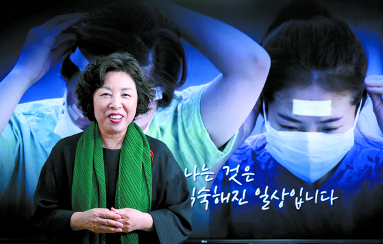 Shin Kyung-rim poses in front of a video that showcases the role of nurses in the coronavirus outbreak. [KIM KYUNG-BIN]