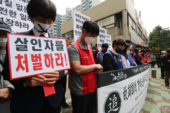 Civic group members hold a vigil Tuesday to mourn a security guard who took his own life after being subject to alleged physical and verbal abuse by an apartment resident. [YONHAP]