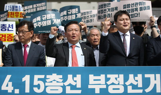 Rep. Min Kyung-wook, center, holds a rally in front of the Supreme Court on May 7 before filing a suit to invalidate the outcome of the April 15 general elections. Min lost to his DP rival Chung Il-young last month.  [YONHAP] 