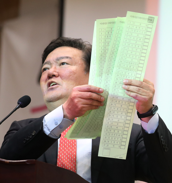 Rep. Min Kyung-wook shows six unmarked ballots during a press conference on Monday, calling them material evidence of vote rigging.  [YONHAP] 