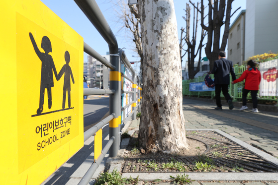 A traffic sign is put up at a childrenprotection zone near and elementary school in Seongdong-district, easternSeoul. [YONHAP] 