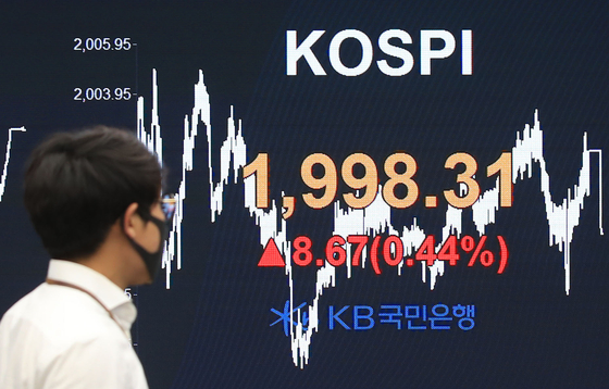  A dealer walks past an electronic signboard in the dealing room of KB Kookmin Bank in Yeouido, western Seoul, Thursday. [YONHAP]