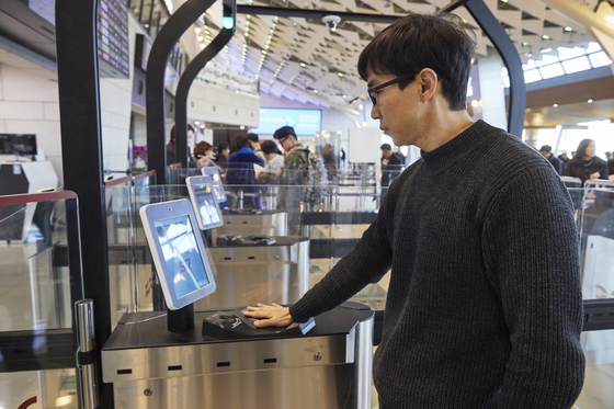 A passenger uses the palm vein authentication system at Gimpo International Airport on Monday. [KWAK JAE-MIN] 