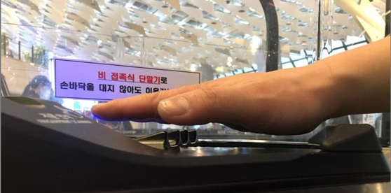 A passenger puts his hand over the palm vein authentication system to enter the departure gate. [KWAK JAE-MIN]