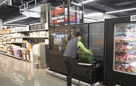 A Lotte Mart employee at the Gwanggyo branch in Suwon, Gyeonggi, prepares an order placed online. [LOTTE SHOPPING]