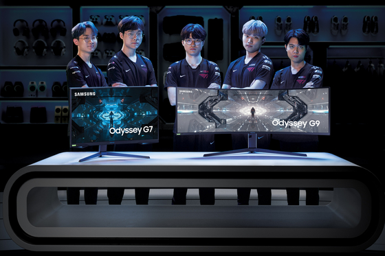 T1's League of Legends team, including three-time world champion Faker, center, stands behind Samsung Electronics' gaming monitors Odyssey G7, left, and G9. [SAMSUNG ELECTRONICS]