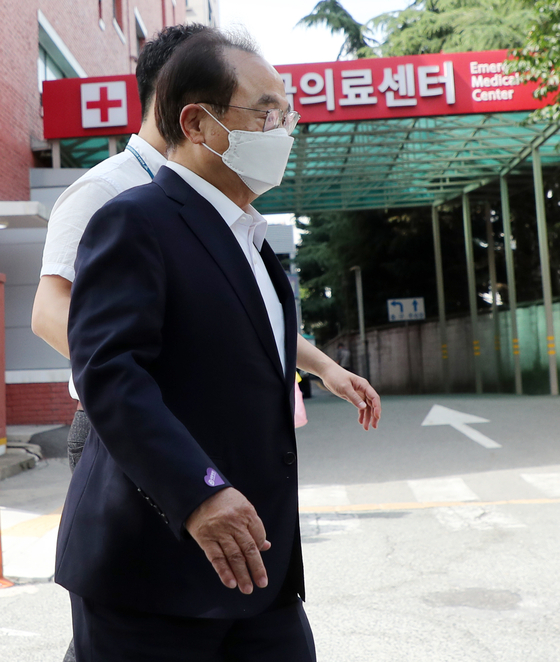 Former Busan Mayor Oh Keo-don is beingtaken to an emergency room at a hospital in Busan on Tuesday. Oh complained offeeling something pressing on his chest while waiting in a police lock-up for acourt’s decision on a detention warrant against him on a charge of sexuallymolesting a female civil servant. [YONHAP]