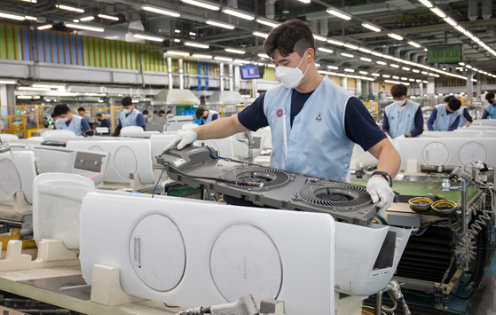  A worker assembles air conditioners at Samsung Electronics’ plant in Gwangju, Gyeonggi, on Tuesday. The company said it is fully operating its air conditioner production lines as it expect a hot summer this year. Temperatures have been rising recently as the heat went up to as much as 28 degrees Celsius (82.4 degrees Fahrenheit) over the weekend, resulting in a sharp increase in sales. [SAMSUNG ELECTRONICS]