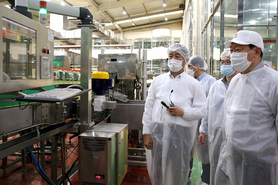 Lotte Group Chairman Shin Dong-bin, right, at Lotte Chilsung Beverage factory in Anseong, Gyeonggi, on Wednesday. [LOTTE CORPORATION] 