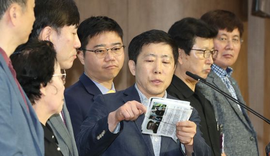 A South Korean right wing civic group leader, third from right, holds up propaganda leaflets his group sent to the North during a press conference with United Future Party lawmakers expressing opposition to a legal ban on the leaflets held at the National Assembly on Monday. [YONHAP]