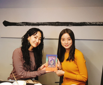 HA:TFELT, left, also known as Ye-eun, gifts her new book to Woo Hye-rim, right. Both were former members of Wonder Girls. [WOO HYE-RIM]