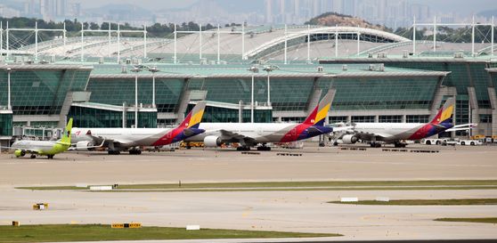 Asiana Airlines planes parked at Incheon International Airport on Wednesday. Korea Development Bank (KDB) released a statement on Wednesday in response to Hyundai Development Company’s request to change the terms of its acquisition of the airline. KDB said HDC should be more specific about possible changes in terms. [YONHAP]