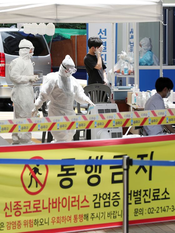 Quarantine officials conduct coronavirus testing on visitors at a makeshift testing facility at a public health center in Songpa District, southern Seoul. A total of 471 students and faculty at a cram school in the area were tested Tuesday after a cook at the school was found with the virus. [NEWS1]