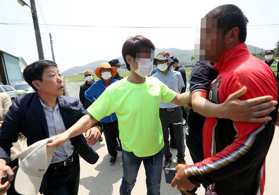 Park Sang-hak, a North Korean defector who heads the civic group Fighters for a Free North Korea, left, clashes with local residents of Ganghwa County, Incheon, after the residents stopped the organization from floating plastic bottles containing leaflets and propaganda across the coast into North Korea. [YONHAP]