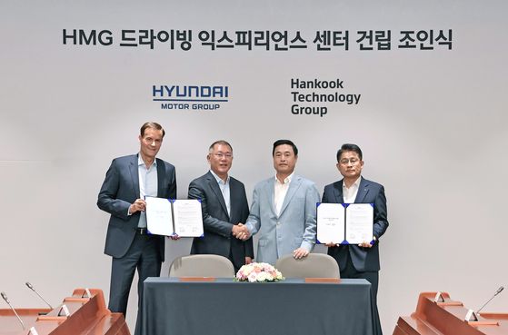Euisun Chung, executive vice chairman at Hyundai Motor Group, second from left, shakes hands with Cho Hyun-sik, vice chairman at Hankook Technology Group, after signing a partnership on the establishment of HMG Driving Experience Center at the automaker's Yangjae headquarters in southern Seoul on June 17. [HYUNDAI MOTOR GROUP]