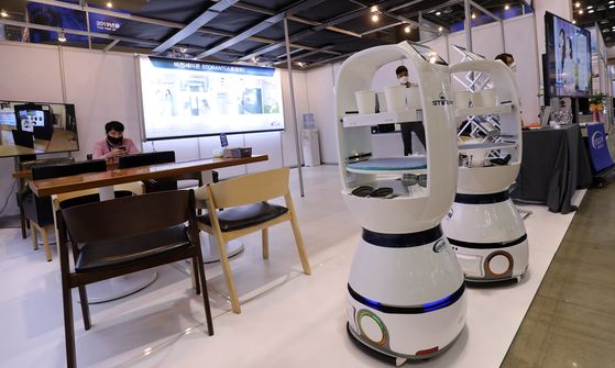 Serving robots serve drinks at a 24-hour unmanned smart robot cafe at Korea Metal Week 2020 held at Kintex in Goyang, Gyeonggi, on Wednesday. The exhibition will last until Saturday, showing off a broad range of innovative ideas for industrial applications. [YONHAP]