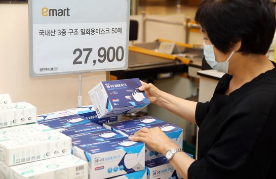 A customer looks at a box of disposable face masks made in Korea at an Emart store. [EMART]