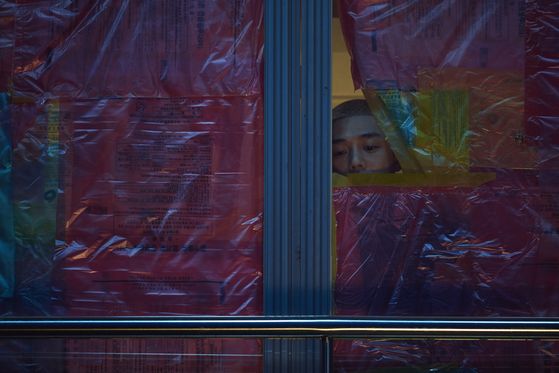 Scene from the film. Joon-woo (played by Yoo Ah-in) peeks through a window to see what's happening outside. [LOTTE ENTERTAINMENT] 