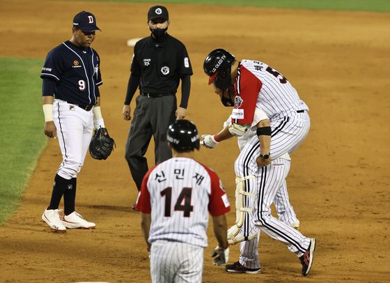 Chae Eun-seong of the LG Twins, right, is carried off the field by a team training after spraining his right ankle during a game against the Doosan Bears at Jamsil Baseball Stadium in Seoul on June 21. [NEWS1]