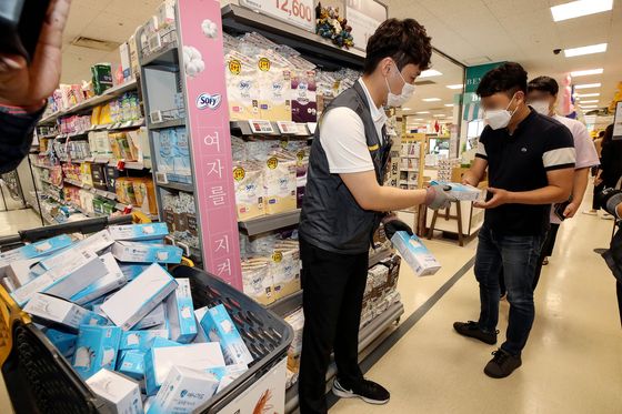 An Emart employee hands out a box of anti-droplet facial masks to a customer at the retailer's branch in Seongsu-dong, eastern Seoul, on Wednesday. The anti-droplet masks are said to be lighter than the KF94 masks, making it easier to breathe. Each customer is limited to 20 masks, which cost 500 won ($0.42) a piece. [YONHAP]