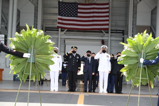 South Korean and U.S. defense and military officials salute the remains of fallen South Korean troops handed off to Seoul in a ceremony at Hawaii on Wednesday. [MINISTRY OF NATIONAL DEFENSE]