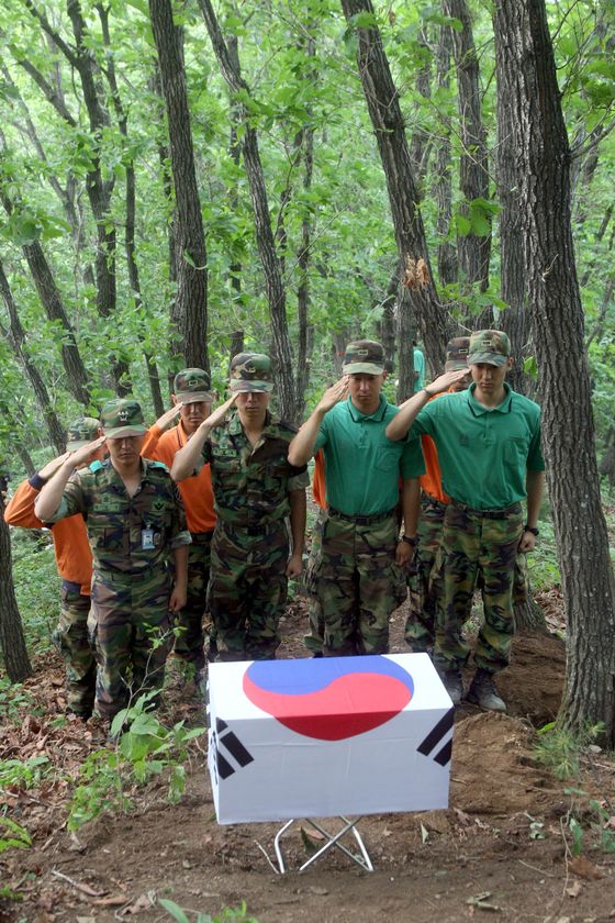 Officers of the Ministry of National Defense's Agency for KIA Recovery and Identification salute a box containing the remains of South Korean soldiers recovered from a Korean War battlefield. [CHOI JEONG-DONG]