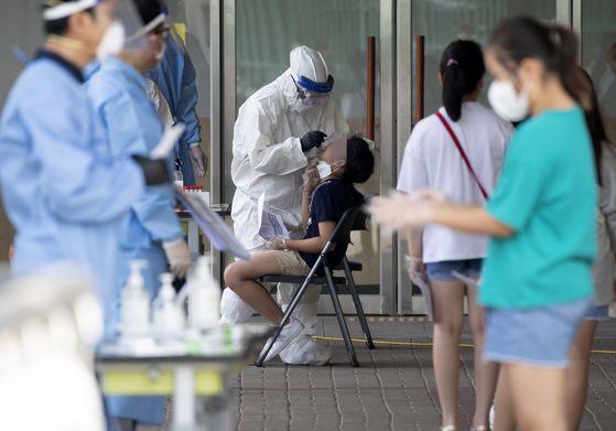Students get tested for Covid-19 at a center set up at Nanwoo Elementary School in Gwanak District, southern Seoul, on Sunday, after a lecturer at the school was diagnosed with the coronavirus. [YONHAP]