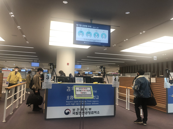Travelers have their temperatures taken as they enter Korea on March 29. [JIM BULLEY]