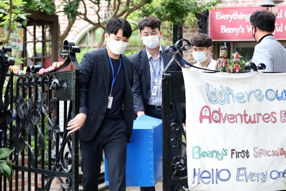 Police officers on Monday morning carry out boxes after raiding a kindergarten in Ansan, Gyeonggi, where a mass outbreak of food poisoning resulted in children hospitalized with the so-called hamburger disease. [NEWS1]