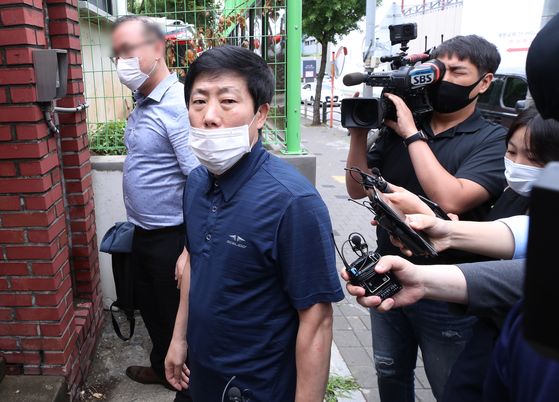 Park Sang-hak, head of Fighters for a Free North Korea, looks at the press before stepping into police offices in western Seoul for questioning on Tuesday. [YONHAP]