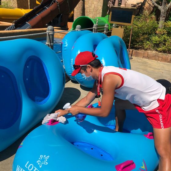 An employee of Lotte Water Park sanitizes a tube for water slides prior to its operation. [LOTTE WATER PARK]
