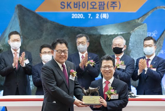 SK Biopharmaceuticals CEO Cho Jeong-woo, left, and Jung Ji-won, CEO and chairman of Korea Exchange pose for a photo holding a memorial tablet celebrating the company's public listing on July 2 at the exchange's headquarters in Yeouido, western Seoul. [YONHAP]