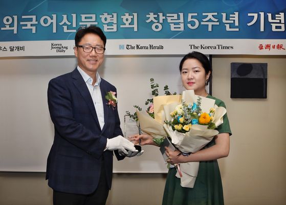 Ryu Kwon-ha, left, CEO of the Korea JoongAng Daily, and Yoon So-yeon, right, a culture reporter at the Korea JoongAng Daily, pose for a photo after the Foreign Language Newspapers Association of Korea selected Yoon as one of five outstanding reporters of the year during the event celebrating the fifth anniversary of the association on Monday. Yoon was credited with writing stories, creating video news clips on K-pop and providing prompt news on Korean pop culture.  [PARK SANG-MOON]