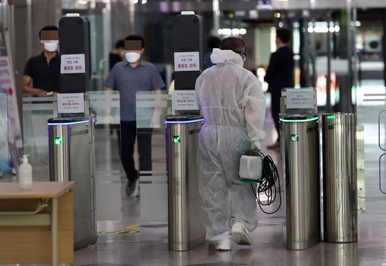 A quarantine official arrives at a government buildng in Daejeon on Monday after an official tested positive on Wednesday. [YONHAP]