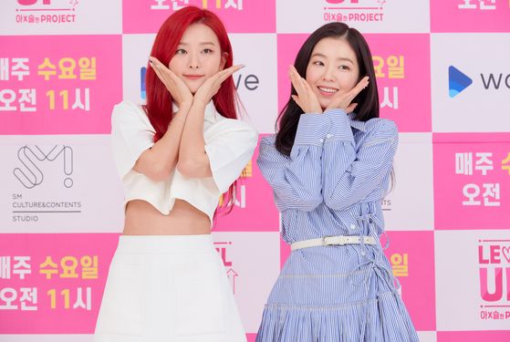 Irene, right, and Seulgi of Red Velvet pose for photos during an online press conference held on Thursday afternoon for the new online reality series "Level Up Project." [SM C&C]