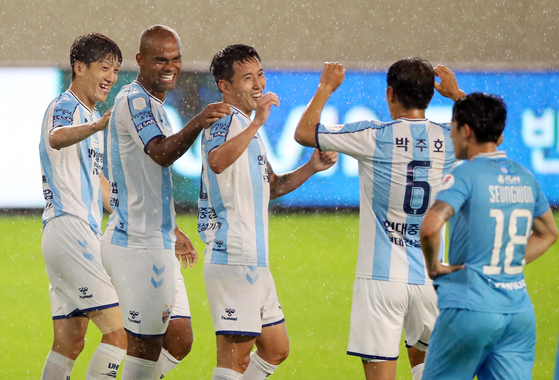 Ulsan Hyundai FC players, in stripes, celebrate after Junior Negrao scores the club's second goal against Daegu FC at the DGB Daegu Bank Park in Daegu on Sunday. [YONHAP]