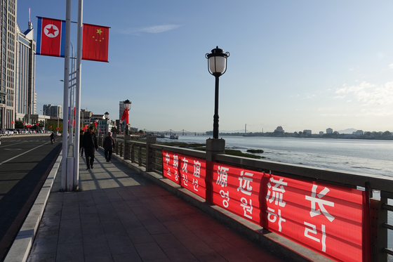 North Korean and Chinese flags decorate the streets of Dandong, China, in October last year, as the two countries celebrated their 70th anniversary of bilateral relations. [YONHAP]