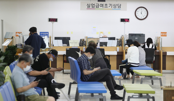 People wait to apply for unemployment benefits at a center in Jung District, central Seoul, on Monday. [YONHAP]