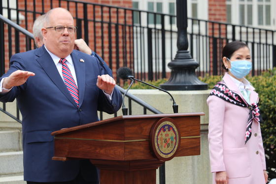 Maryland Gov. Larry Hogan, speaking at a news conference on April 20, announces that the state had received 500,000 Covid-19 test kits from South Korea with the help of his wife, Yumi Hogan, right. [AP/YONHAP]