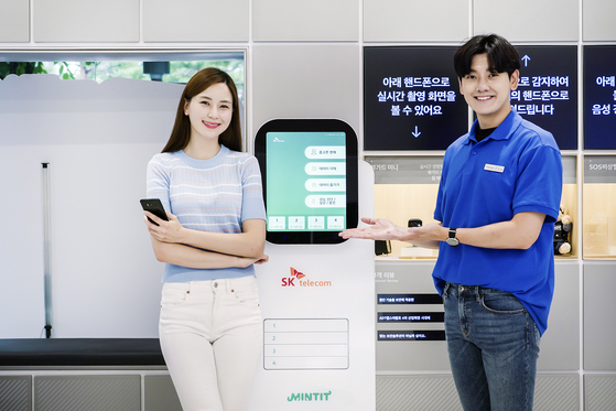 SK Telecom employees posing next to an A.I. (artificial intelligence) kiosk that completely erases all data that are stored on a customer’s mobile phone that cannot be recovered. SK Telecom, the leading mobile telecommunication service provider, on Sunday said it is introducing three innovative retail service including direct delivery of ordered phones to customers, stronger privacy protection and unmanned stores. [SK TELECOM]
