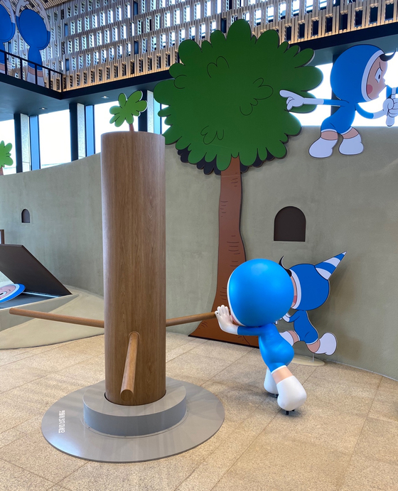 A kinetic installation of a millstone where visitors can try grinding the millstone along with Yumi's cells. [KIM YEON-AH]